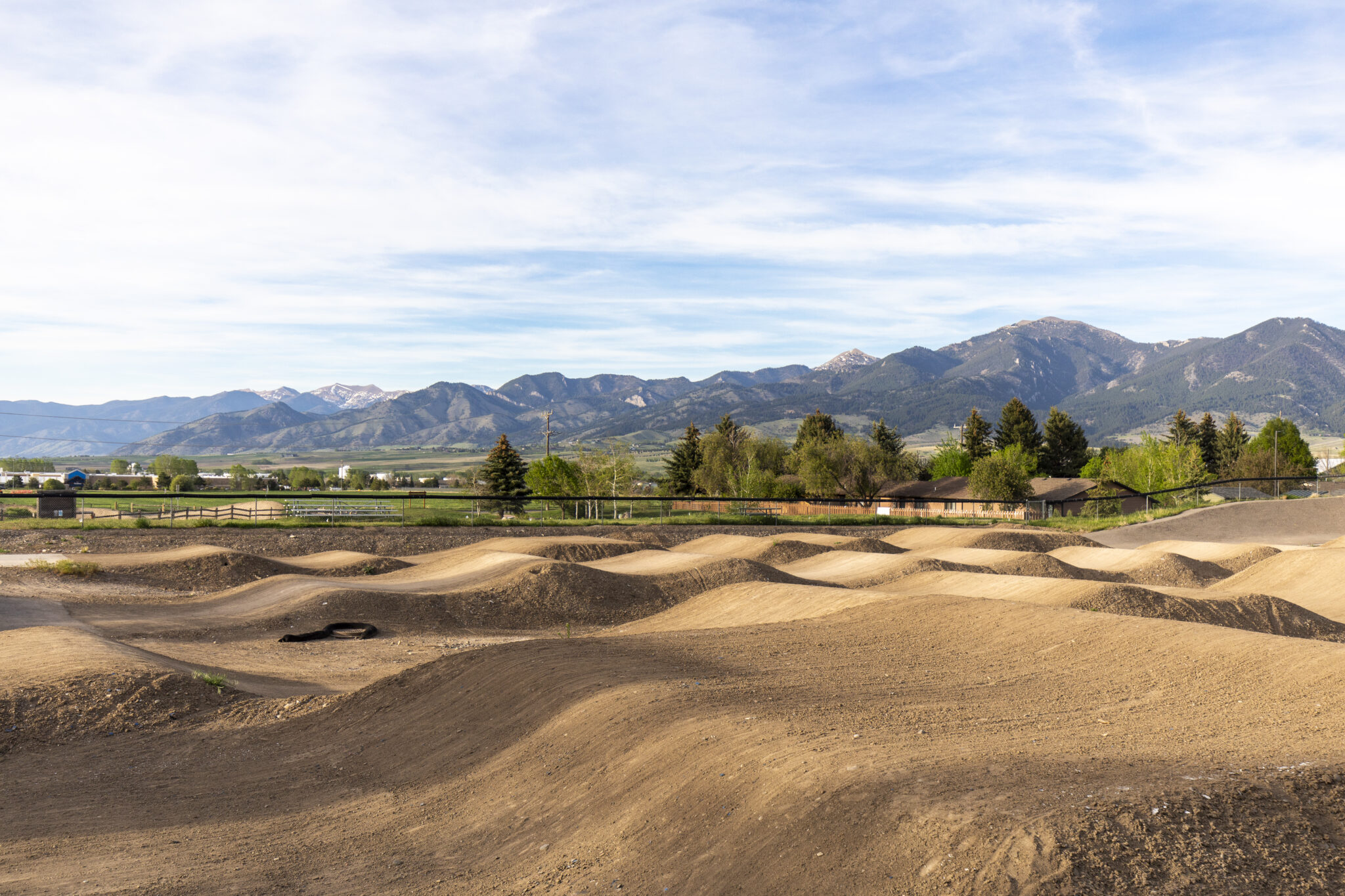 Dirt bike pump track with rolling jumps below the Bridger Mountains near Bozeman