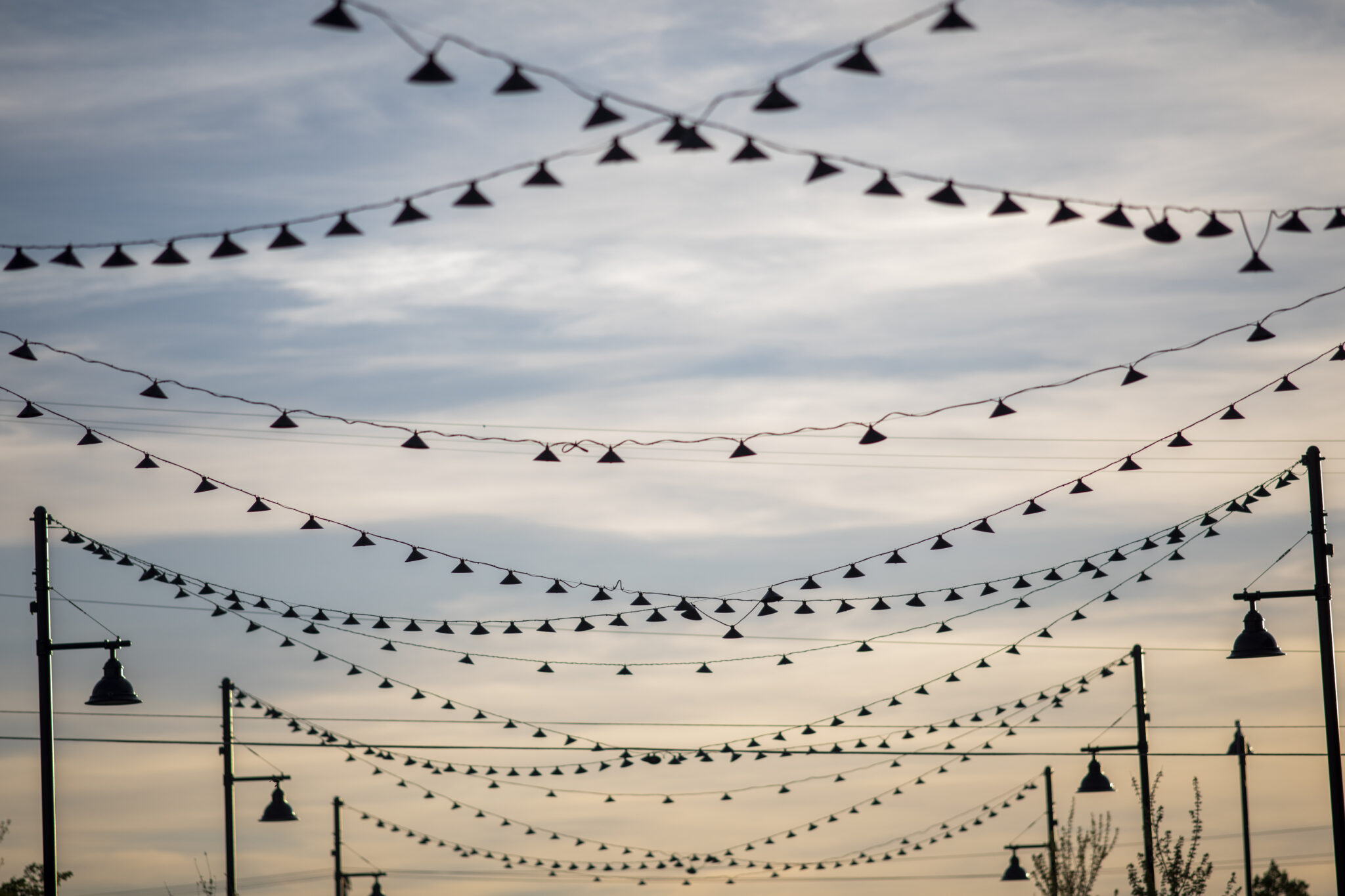 String lights crisscrossing against a soft sunset sky in Bozeman, Montana