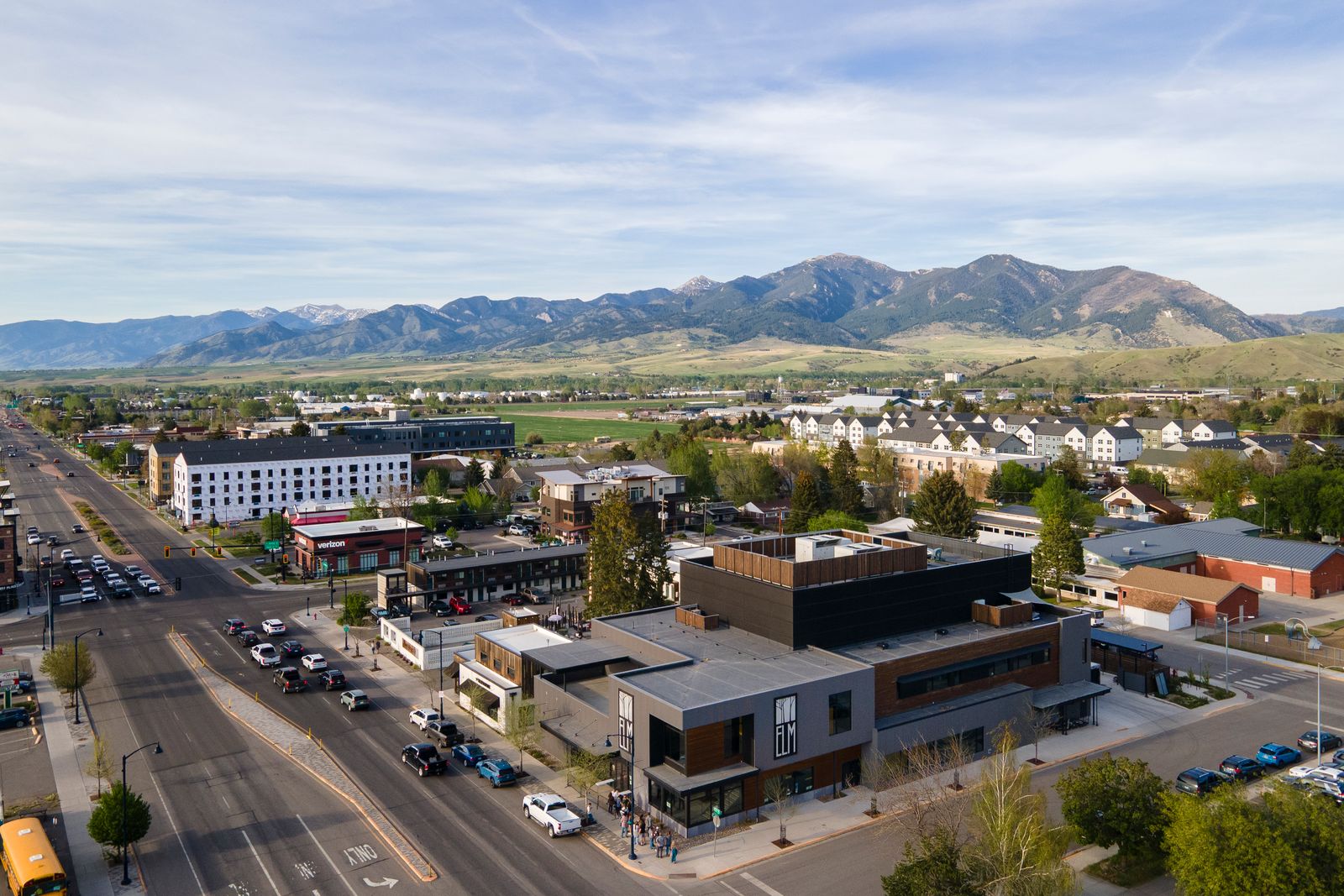 Aerial view of Bozeman, Montana neighborhoods and businesses below green foothills